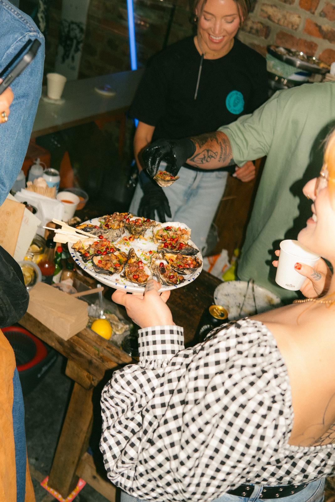 A shared platter of cooked oysters at an event